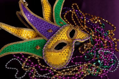 Mardi gras maskesi ve mor zemin üzerine boncuk