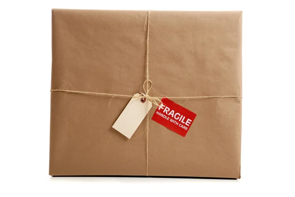 Una caja envuelta en papel marrón con etiqueta en blanco — Foto de Stock