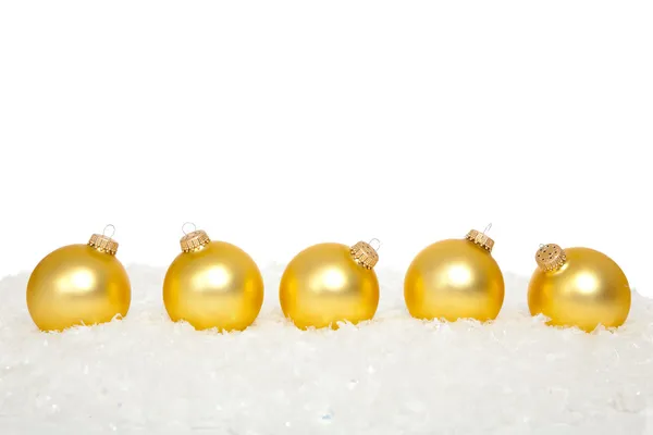 Gold Christmas ornaments in snow — Stock Photo, Image