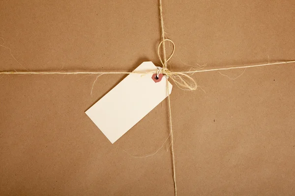 A box wrapped in brown paper with blank tag — Stock Photo, Image