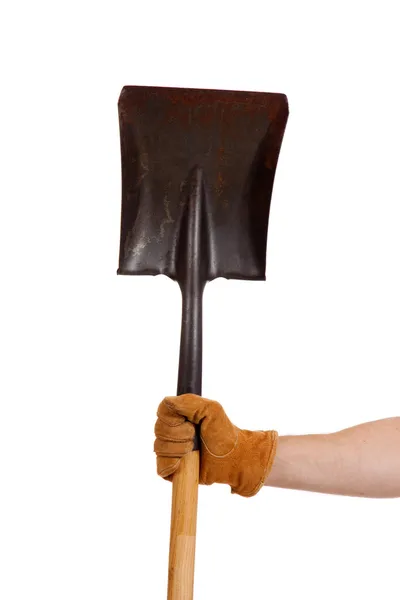 En behandskade hand håller en spade — Stockfoto