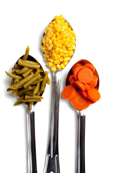 Três colheres com verduras no branco — Fotografia de Stock