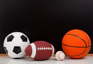 Siyah tebeşir tahta arka plan ile çeşitli spor top