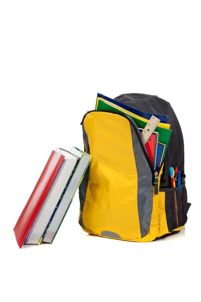 Rucksack mit Schulmaterial auf weißem Hintergrund — Stockfoto