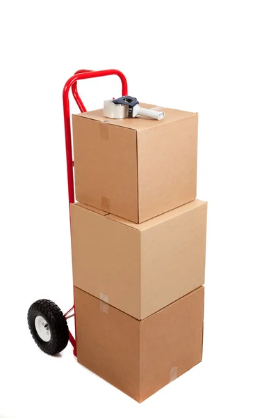 Cardboard boxes on a red hand truck — Stock Photo, Image