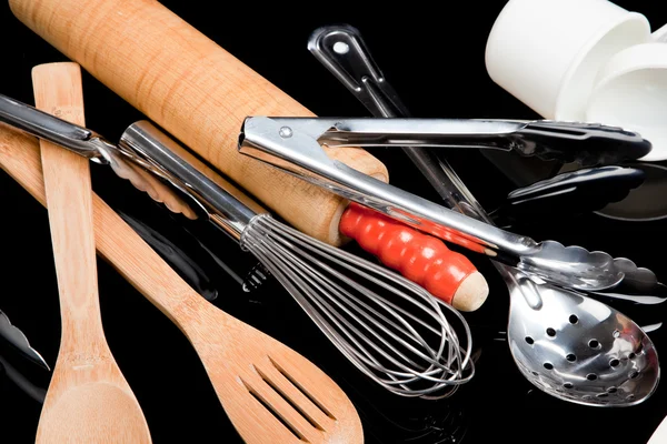 Assorted cooking utensils on black — Stock Photo, Image