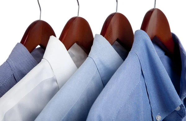 Camisas de vestir azules en perchas de madera — Foto de Stock