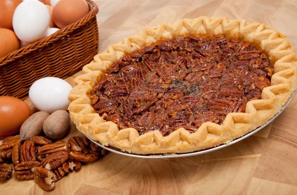 Pecan pie with ingredients on a cutting board — Stock Photo, Image
