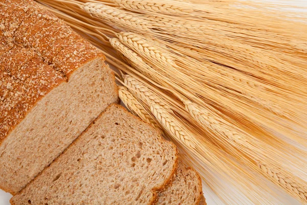 Loaf of wheat bread and shocks of wheat — Stock Photo, Image