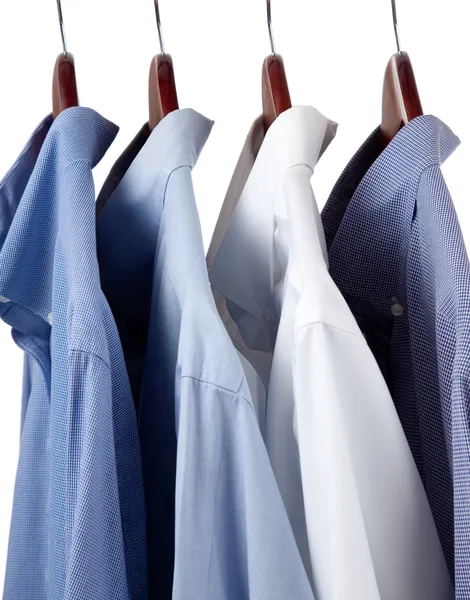 Blue dress shirts on wooden hangers — Stock Photo, Image