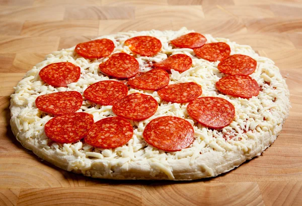 Pizza de pepperoni congelada em uma placa de corte — Fotografia de Stock