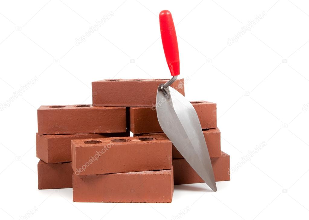 Bricks and a trowel on white
