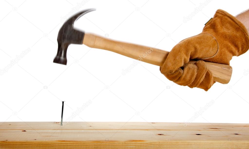 A gloved hand hammering a nail
