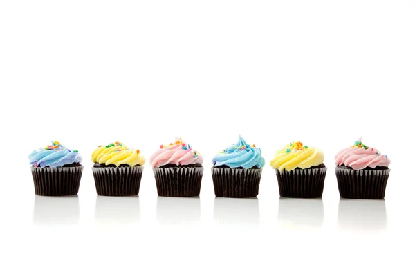 A row of pastel cupcakes on a white background — Stock Photo, Image