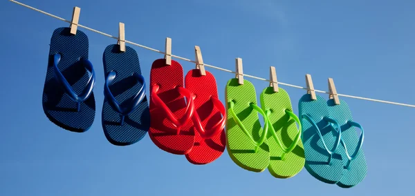 Row of flipflops against a blue sky — Stock Photo, Image