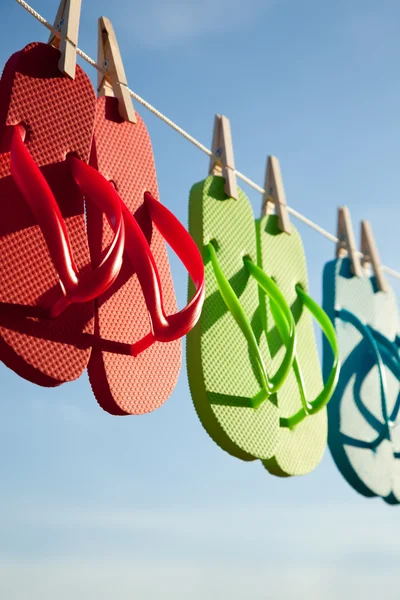 Row of flipflops against a blue sky — Stock Photo, Image