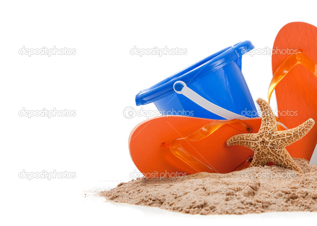 Beach scene with flipflops, sand, bucket and starfish