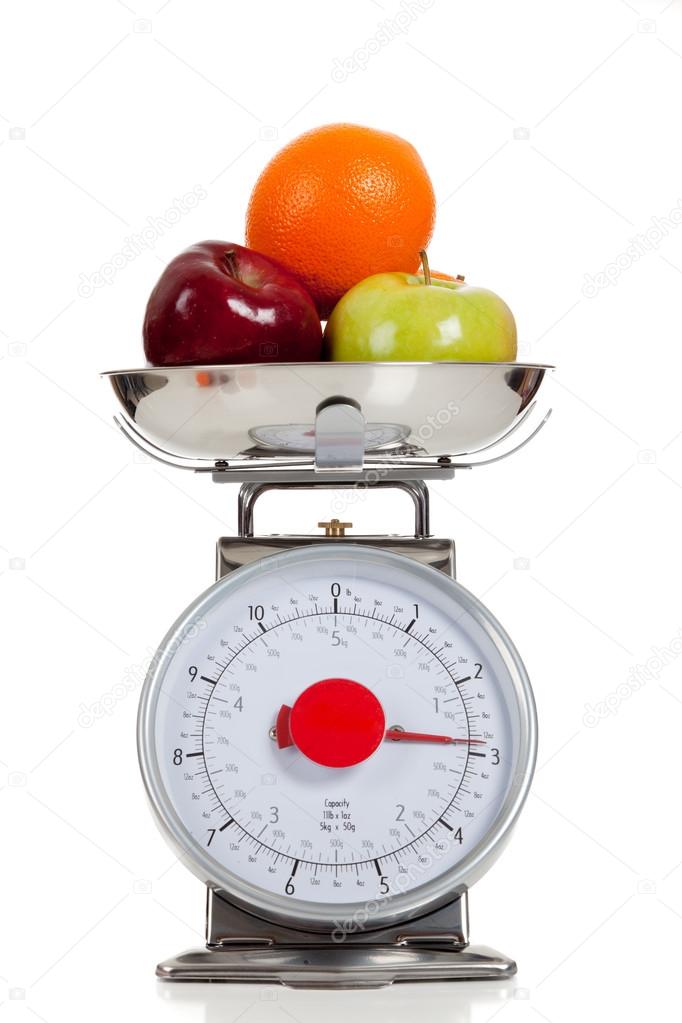 Fruit on a scale with a white background