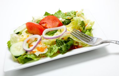 beyaz zemin üzerine bir tabak salata attı