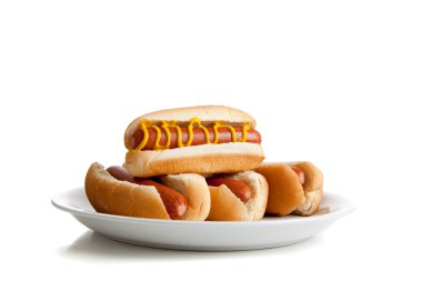 Stacked hot dogs with mustard and buns on white