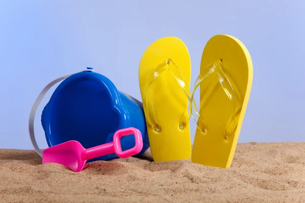 Vödör, lapát, és flipflops a strandon — Stock Fotó