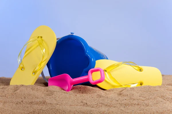 Wiadra, łopaty i klapki na plaży — Zdjęcie stockowe