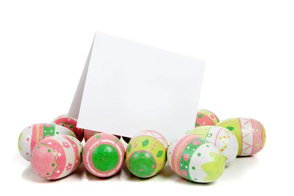 Huevos de Pascua decorados en blanco con una notecard en blanco — Foto de Stock