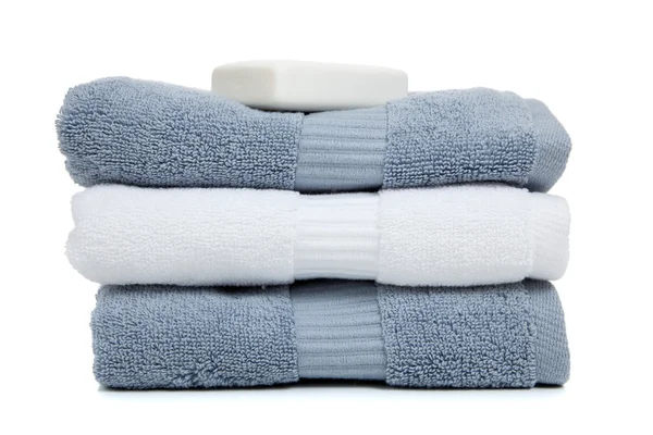 Gray blue and white towels with a bar of soap on white — Stock Photo, Image