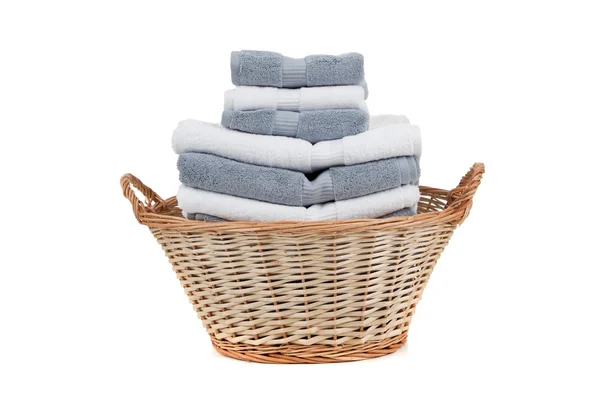 Cesta de lavandaria de vime cheia de toalhas brancas e cinzentas — Fotografia de Stock