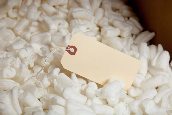 Packing styrofoam and shipping label — Stock Photo, Image