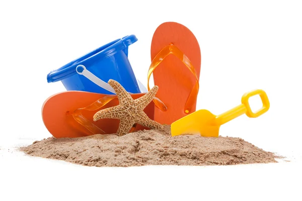 Escena de playa con cubo, chanclas, estrella de mar y pala — Foto de Stock