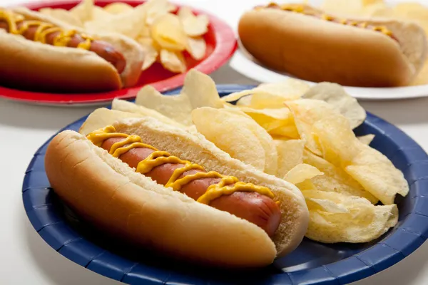 Several hotdogs on colored plates — Stock Photo, Image