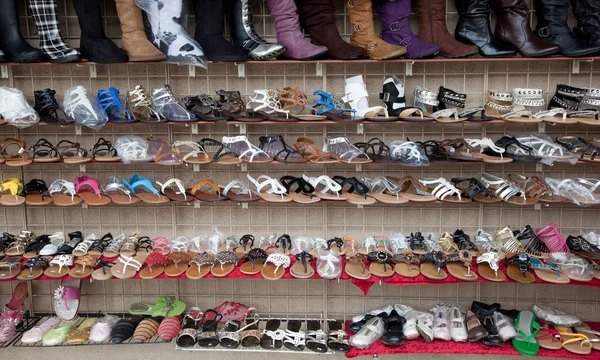 Linhas de sapatos variados, sandálias e botas — Fotografia de Stock