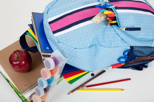 Blue backpack full of supplies on white — Stock Photo, Image