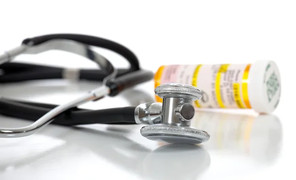 Stetoscopio e flacone di prescrizione su sfondo bianco — Foto Stock