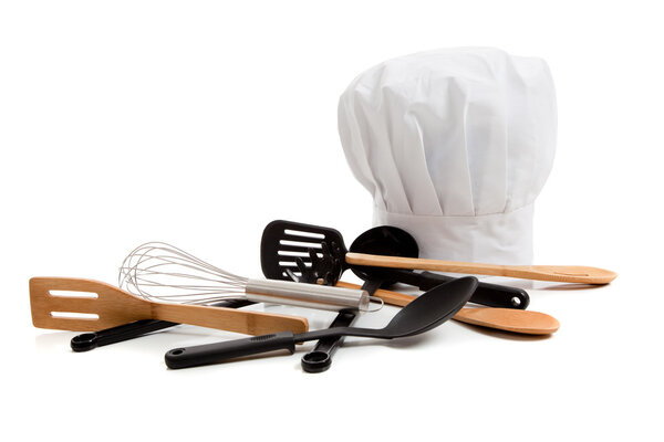 Chef's toque with various cooking utensils on white