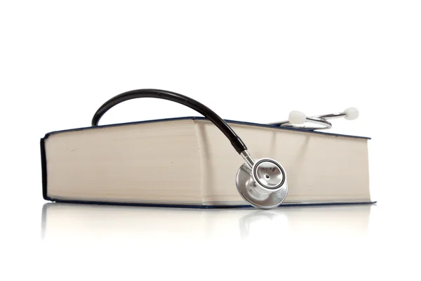 Libro di referenze mediche con uno stetoscopio su bianco — Foto Stock