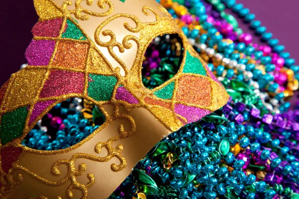 Gold mardi gras mask and beads — Stock Photo, Image