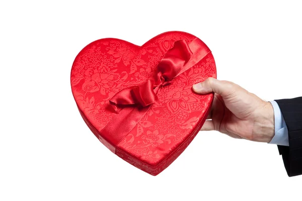 Homem segurando rosas e coração vermelho com chocolates em branco — Fotografia de Stock