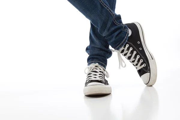 Vintage, scarpe sportive antiche su sfondo bianco con jeans — Foto Stock