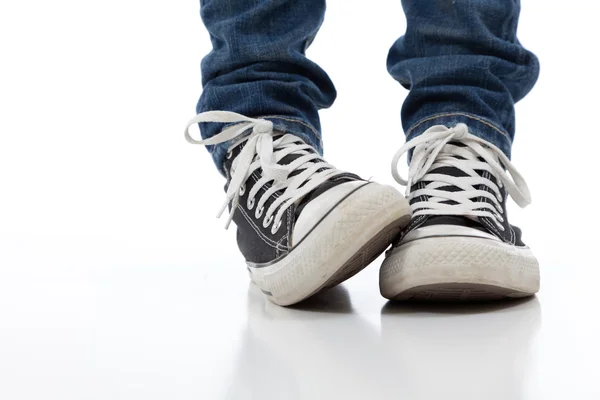 Vintage, scarpe sportive antiche su sfondo bianco con jeans — Foto Stock