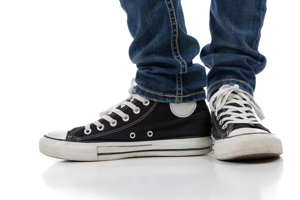 Vintage, zapatos deportivos antiguos sobre un fondo blanco con jeans — Foto de Stock