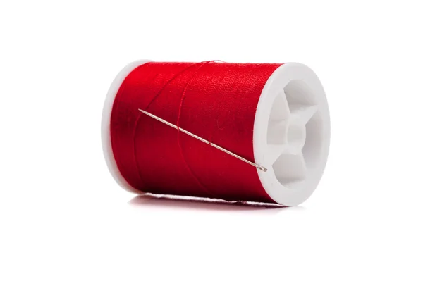 Bobine de fil rouge et aiguille sur blanc — Photo