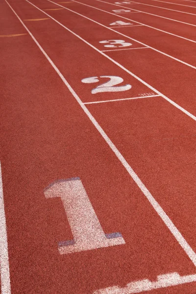 Lanes em uma pista de corrida atlética com o número 1 em primeiro plano — Fotografia de Stock