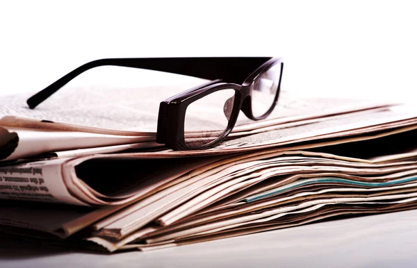 Leesbrillen op kranten — Stockfoto