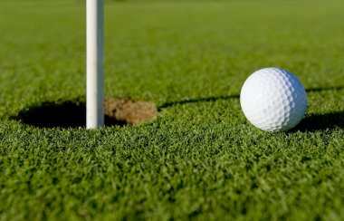 Golf topu deliğe yakın