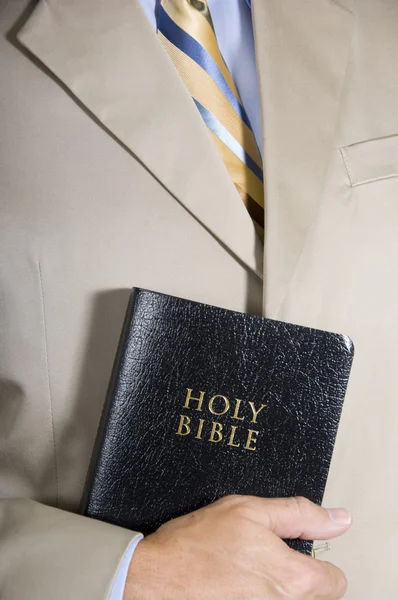 Hombre de negocios o predicador sosteniendo una Biblia de cuero — Foto de Stock