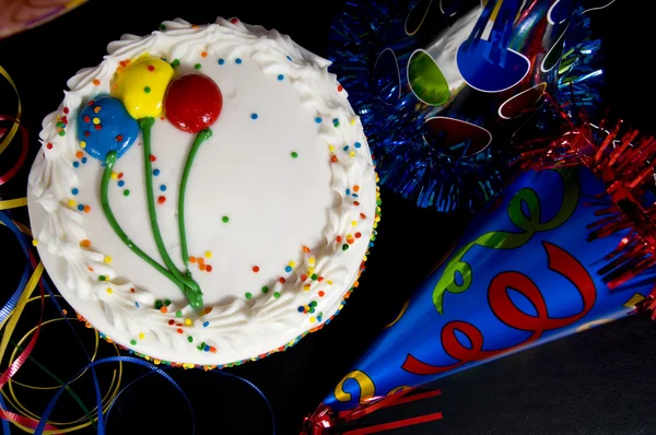 Tarta de cumpleaños y sombreros de fiesta — Foto de Stock