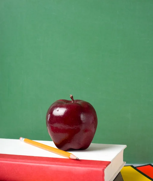 Libros escolares y una manzana — Foto de Stock