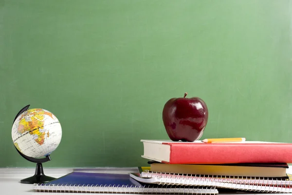 Skolan böcker ett rött äpple och en jordglob — Stockfoto